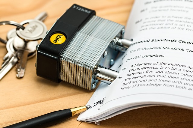 A padlock attached to a document next to keys and a pen