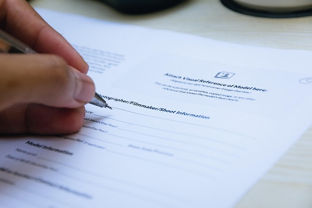 A hand holding a pen signing a paper document