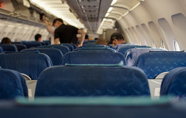The interior of an airplane cabin with blue passenger seats