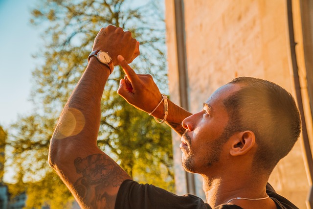 A man pointing at his wristwatch while looking up