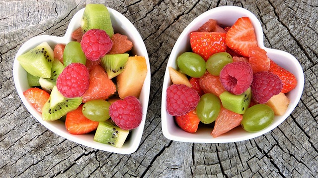 Two heart-shaped bowls filled with fresh mixed fruit salad