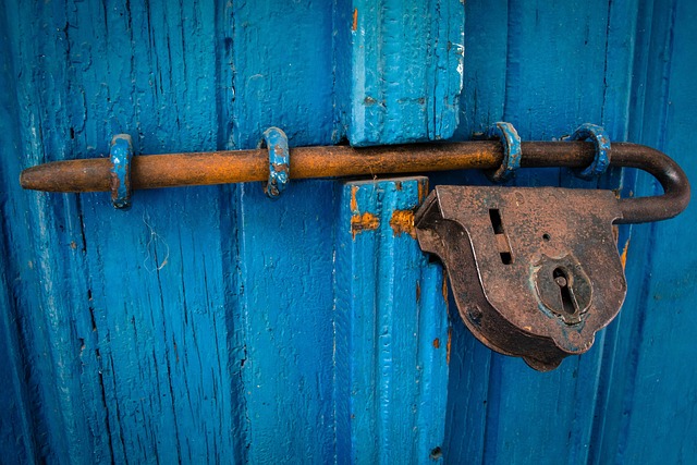 A rusty metal lock and bolt on a blue wooden door